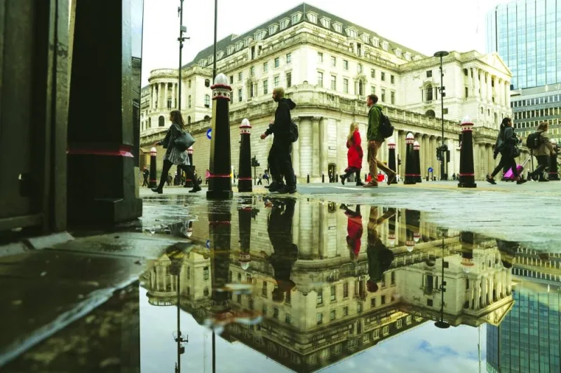 Pedestrians pass the Bank of England in the City of London. The BoE will press on with interest rate rises to battle inflation even though Britain is heading into a long albeit shallow recession, with consumers facing an extended cost of living crisis, a Reuters poll of economists found.
