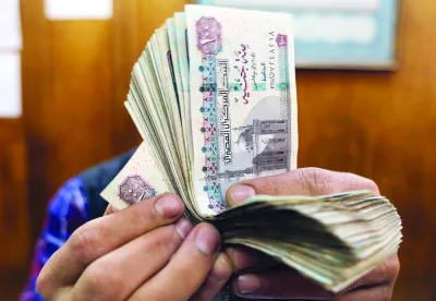 An employee counts Egyptian pounds at a foreign exchange office in central Cairo. Bankers in north Africa's largest economy point out that the Egyptian pound's black market rate of 26-26.5 per dollar is still 8% below the 24.53 official rate despite a 36% overall devaluation this year.