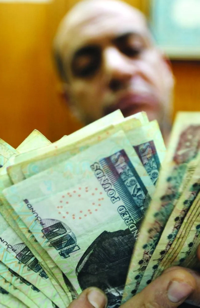 An employee counts Egyptian pounds at a foreign exchange office in central Cairo (file). The North African nation devalued the pound by 18% in late October and signalled it’s shifting to a more flexible foreign-exchange regime as the economy grapples with the fallout from Russia’s invasion of Ukraine