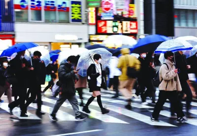 Pedestrians wearing protective face masks walk at a shopping district in Tokyo (file). Japan's economy unexpectedly shrank in the third quarter as global recession risks, China's faltering economy, a weak yen and higher import costs hurt consumption and businesses.