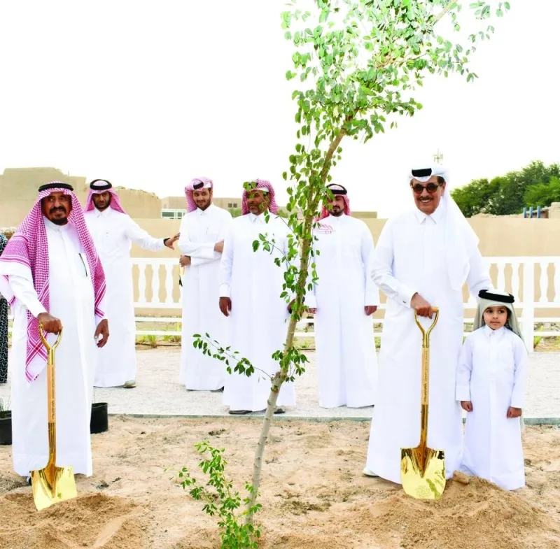 HE Dr Hamad bin Abdelaziz al-Kawari and Al Khater family head planting a tree.