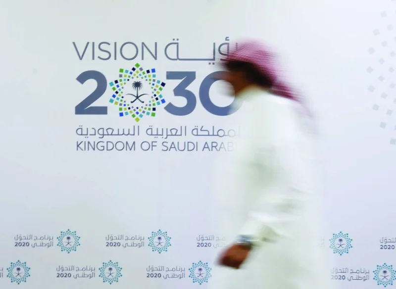 A Saudi man walks past the logo of Vision 2030 after a news conference, in Jeddah, Saudi Arabia June 7, 2016. REUTERS/Faisal Al Nasser