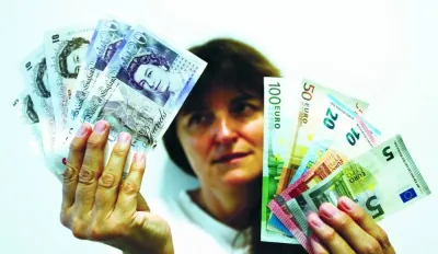An employee holds British pounds and euro banknotes in a bank in Munich. The UK currency is under pressure from the Bank of England turning more cautious on further interest-rate hikes, just as the European Central Bank amps up its rhetoric on the need for more action to tame inflation.