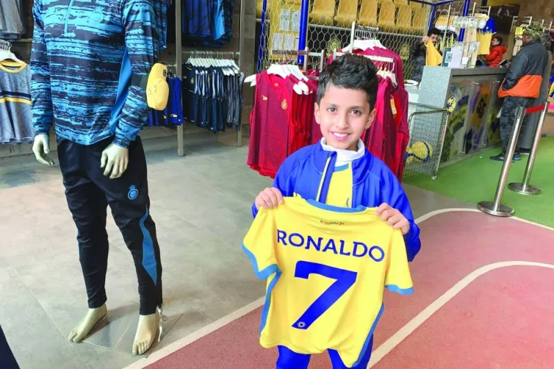 A young fan holds t-shirt bearing the name Ronaldo and number 7, at the Saudi Al Nassr FC shop in the Saudi capital Ryadh, on December 31, 2022.
— Cristiano Ronaldo on December 30 signed for Al Nassr of Saudi Arabia, the club announced, in a deal believed to be worth more than 200 mn euros.
The 37-year-old penned a contract which will take him to June 2025.(Photo by Fayez Nureldine / AFP)