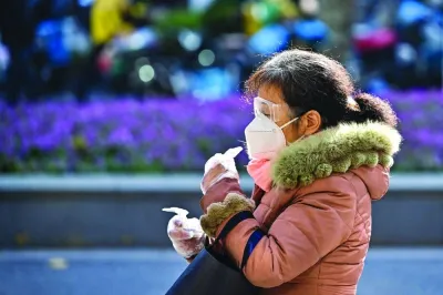 A woman wearing a face mask and goggles walks on a street in the Jing'an district in Shanghai on December 21. China’s abrupt lifting of Covid restrictions in early December has fuelled a surge in infections across the country, adding more uncertainty to the economy’s outlook.