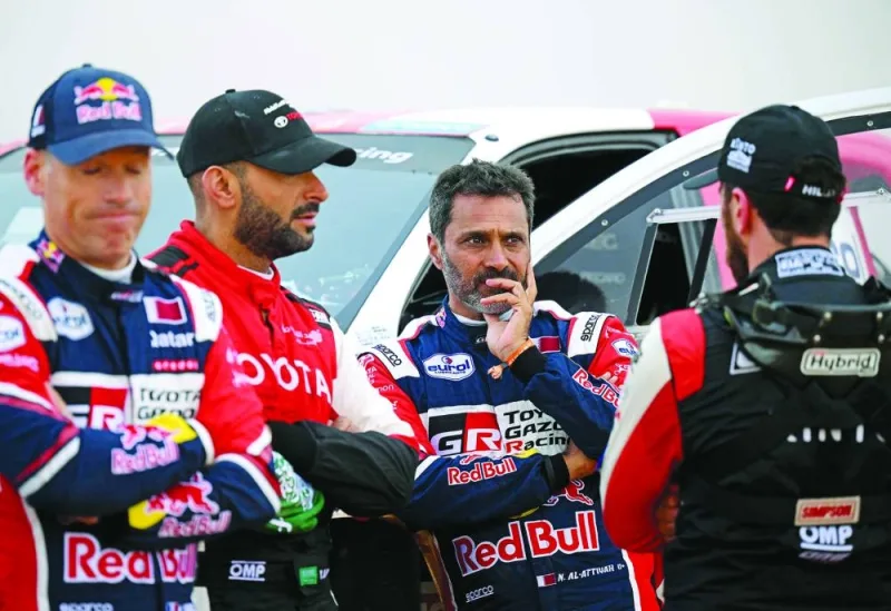 Toyota’s driver Nasser Saleh al-Attiyah of Qatar (second right) looks on after the third stage of the Dakar Rally between Al-Ula and Ha’il in Saudi Arabia was cancelled due to the degradation yesterday. (AFP)