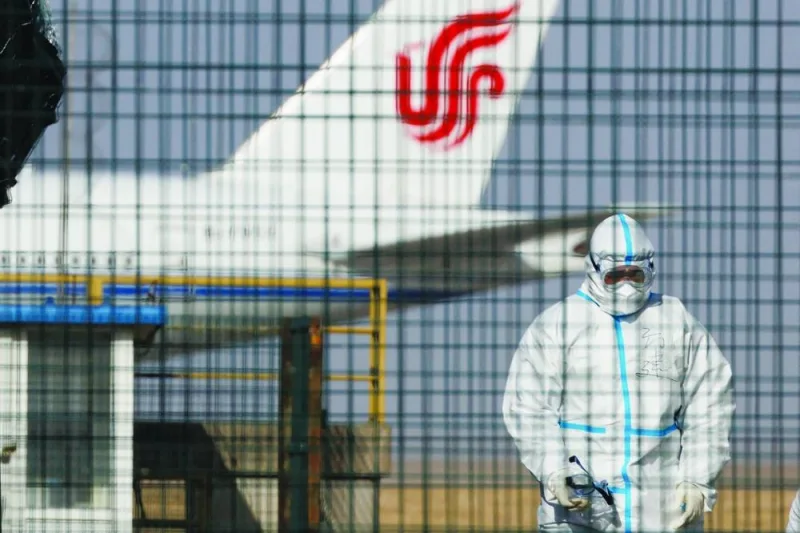 A worker in a protective suit walks near a plane of Air China airlines at Beijing Capital International Airport as coronavirus disease (Covid-19) outbreaks continue in Beijing.