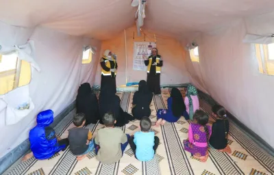 File photo shows civil defence members talk to internally displaced Syrians during a cholera awareness campaign, at a camp in northern rebel-held Idlib.