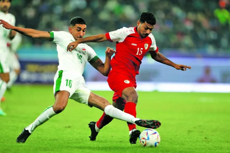 Iraq’s Amir al-Ammari (left) and Oman’s Musab Hamad al-Maamari vie for the ball during the opening match of the Arabian Gulf Cup at the Basra International Stadium on Friday.