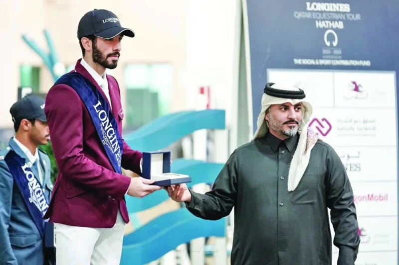 Event Director Ali Bin Yousef al-Rumaihi (right) presents a trophy to Ghanim Nasser al-Qadi (also left), who won the Open Class and also took third place yesterday. Khaled Mohamed al-Emadi came second.