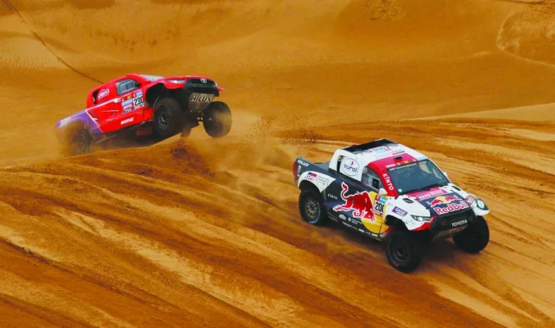 From left: Overdrive Racing’s Brazilian driver Lucas Moraes and German co-driver Timo Gottschalk chase Toyota’s Qatari driver Nasser al Attiyah and his French co-driver Mathieu Baumel during Stage 8 of the Dakar 2023 between Al Duwadimi and Riyadh in Saudi Arabia yesterday. (Reuters)