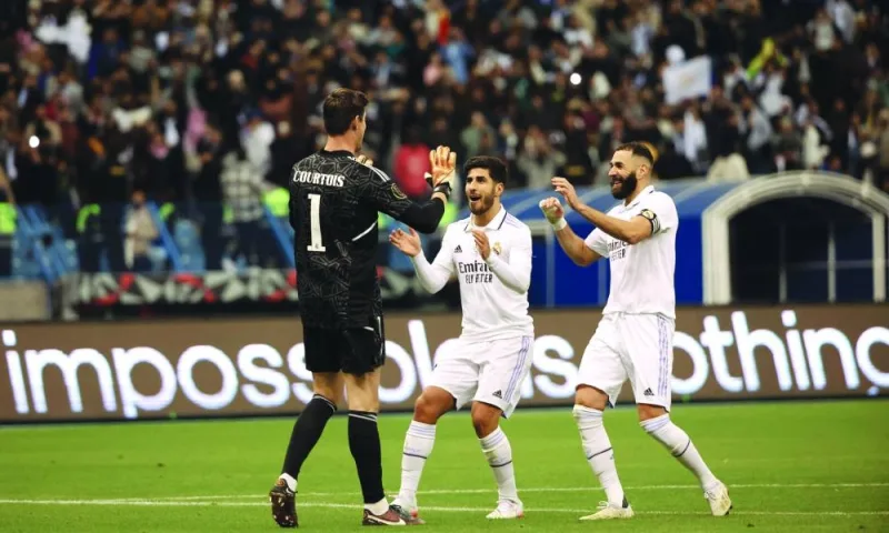 Real Madrid’s forward Karim Benzema (right), goalkeeper Thibaut Courtois and midfielder Marco Asensio (centre) celebrate after winning the Spanish Super Cup semi-final against Valencia CF at the King Fahd International Stadium in Riyadh yesterday. (AFP)