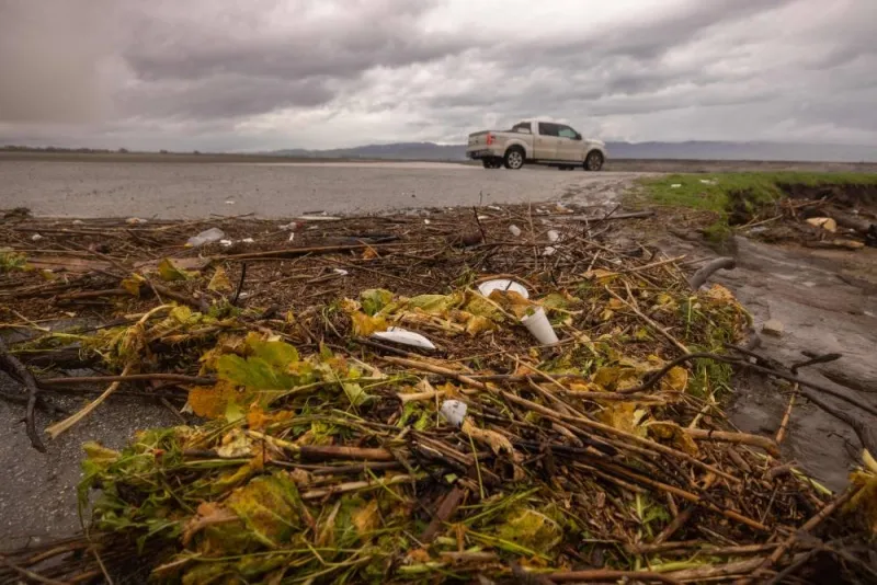 Produce from farms flooded by the Salinas River is deposited on the bank of the river near Chualar, California, on January 14, 2023, as a series of atmospheric river storms continue to cause widespread destruction across the state. (AFP)