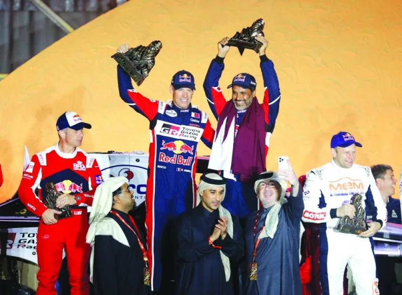 Qatar Motor & Motorcycle Federation (QMMF) president Abdulrahman al-Mannai (bottom left) looks on as Qatar’s Nasser al-Attiyah celebrates on the podium after winning the Dakar Rally in Dhahran, Saudi Arabia. (Reuters)