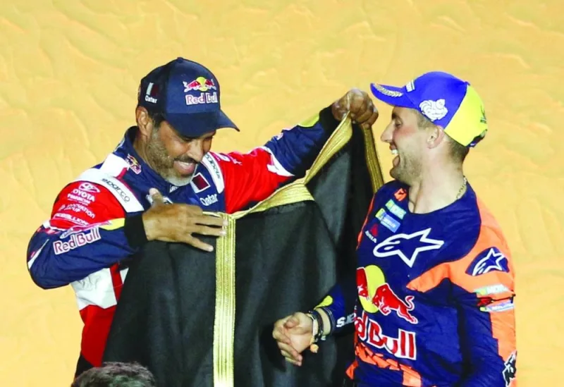 Red Bull KTM Factory Team’s Kevin Benavides (right) celebrates on the podium after winning the bike category alongside winner of the car category Toyota Gazoo Racing’s Nasser al-Attiyah. (Reuters)