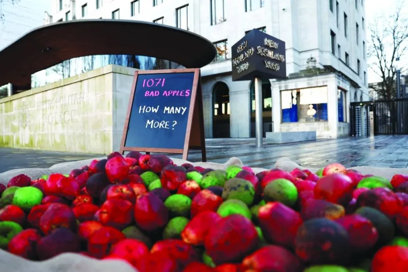 Plastic rotten apples left by members of the domestic violence charity 'Refuge' are seen outside New Scotland Yard during a protest in London.