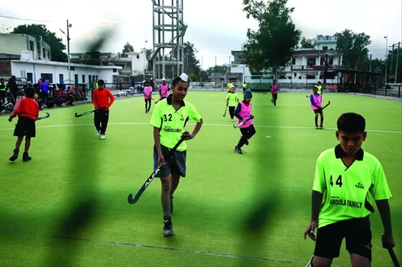 In this photograph taken on January 18, 2023, students practice on a hockey pitch in Sansarpur village in India’s Punjab state. Kids with sticks dribble balls, weave and bob in Sansarpur, the cradle of Indian field hockey. But the village’s glory days, as well as those of the national team, are a thing of the past. (AFP) 