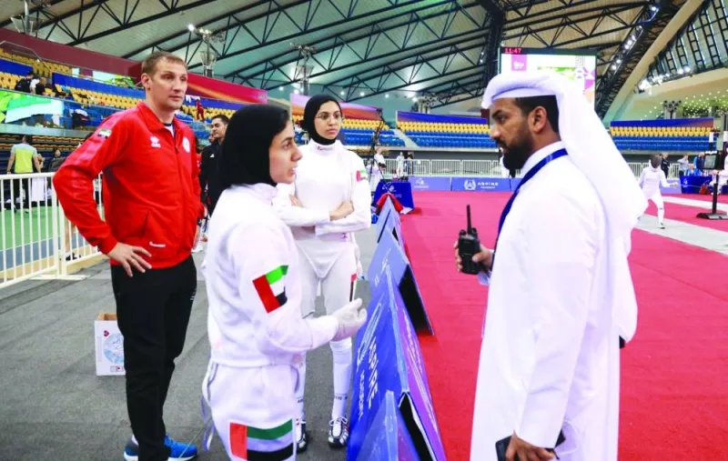 A gymnast talks to a member of local the organising committee on day one of the Qatar Grand Prix Fencing Championship in Doha.
