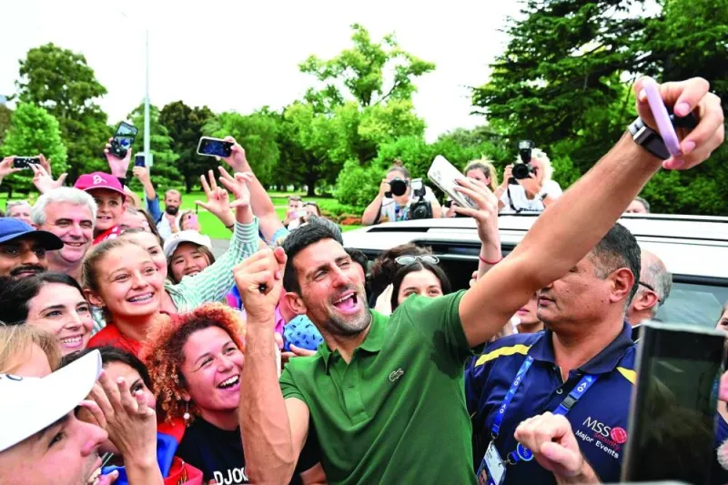 Serbia’s Novak Djokovic gets selfies with his supporters outside the Government House  in Melbourne after winning the Australian Open final against Greece’s Stefanos Tsitsipas. (AFP) 