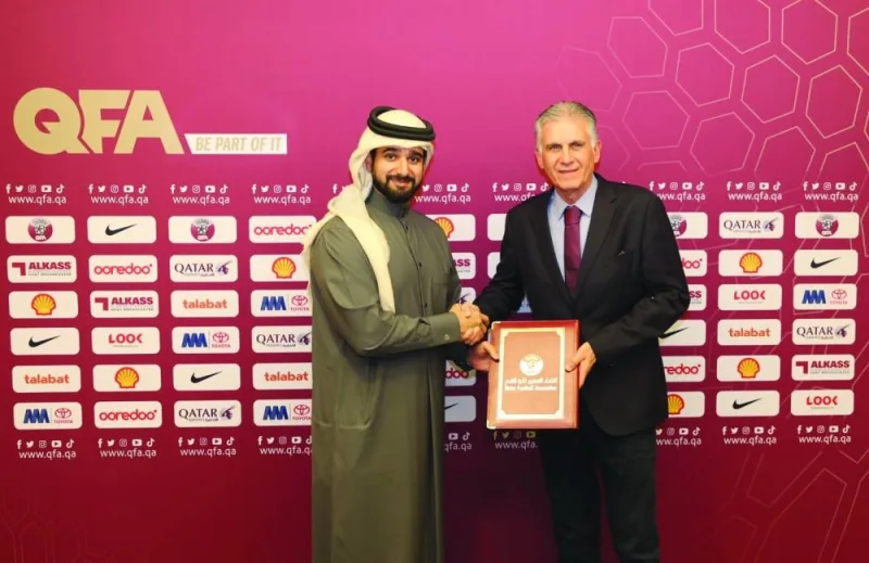 Qatar Football Association secretary-general Mansoor al-Ansari (left) shakes hands with Carlos Queiroz in Doha yesterday. QFA has signed a contract with Queiroz who takes over as new Qatar coach. Below: Al-Ansari and Queiroz sign the contract.
