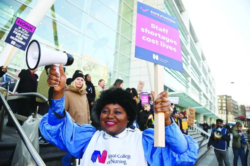 A person holds a megaphone and a sign as nurses protest during a strike by NHS medical workers, amid a dispute with the government over pay, outside University College London Hospital in London, Britain, yesterday.