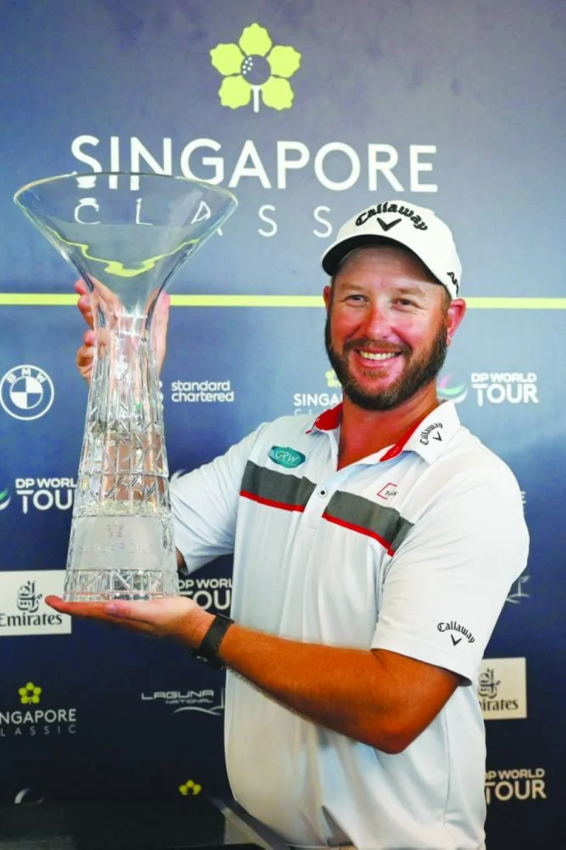 Ockie Strydom of South Africa poses with the trophy after winning the DP World Tour Singapore Classic in Singapore yesterday. (AFP)