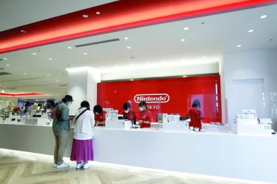 Store attendants serve customers from behind plastic screens at the check-out counter inside the Nintendo TOKYO store in Tokyo (file). The PIF now owns 8.3% of the Kyoto-based games company, according to a filing, building up a position that stood just above 6% at the start of the year.