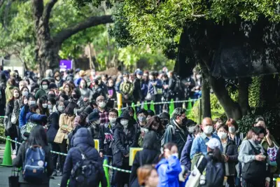 People wait in line to look at the female giant panda Xiang Xiang ahead of her return to China, at Ueno Zoological Park in Tokyo yesterday.