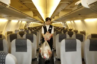 A cabin attendant carries bags of trash as she conducts her cleaning duties in the cabin of a Japan Airlines airplane at Haneda Airport in Tokyo (file). The passenger cabin is seen as a highly visible element of aviation industry’s environmental performance. The airline industry has been always the subject of criticism for inadequate cabin waste recycling, which threatens the sector’s environmental reputation. 