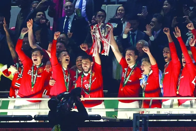 Manchester United players celebrates with the trophy after winning the League Cup final against Newcastle in London. (Reuters)