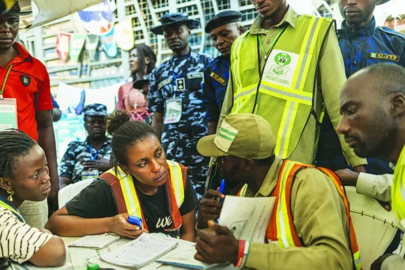 Independent National Electoral Commission (INEC) officials collate electoral results before returning the electoral materials to the INEC offices in Abuja, yesterday, the day after Nigeria's presidential and general election.