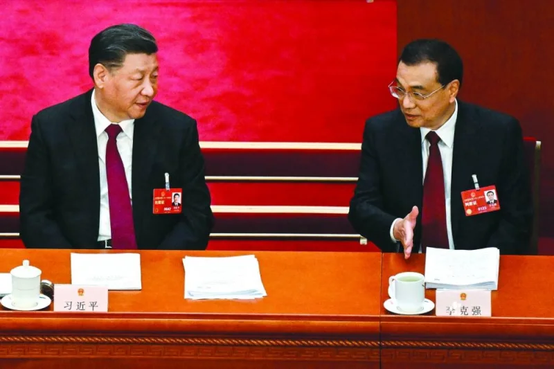 China’s President Xi Jinping (left) speaks with Premier Li Keqiang during the opening session of the National People’s Congress at the Great Hall of the People in Beijing yesterday. (AFP)