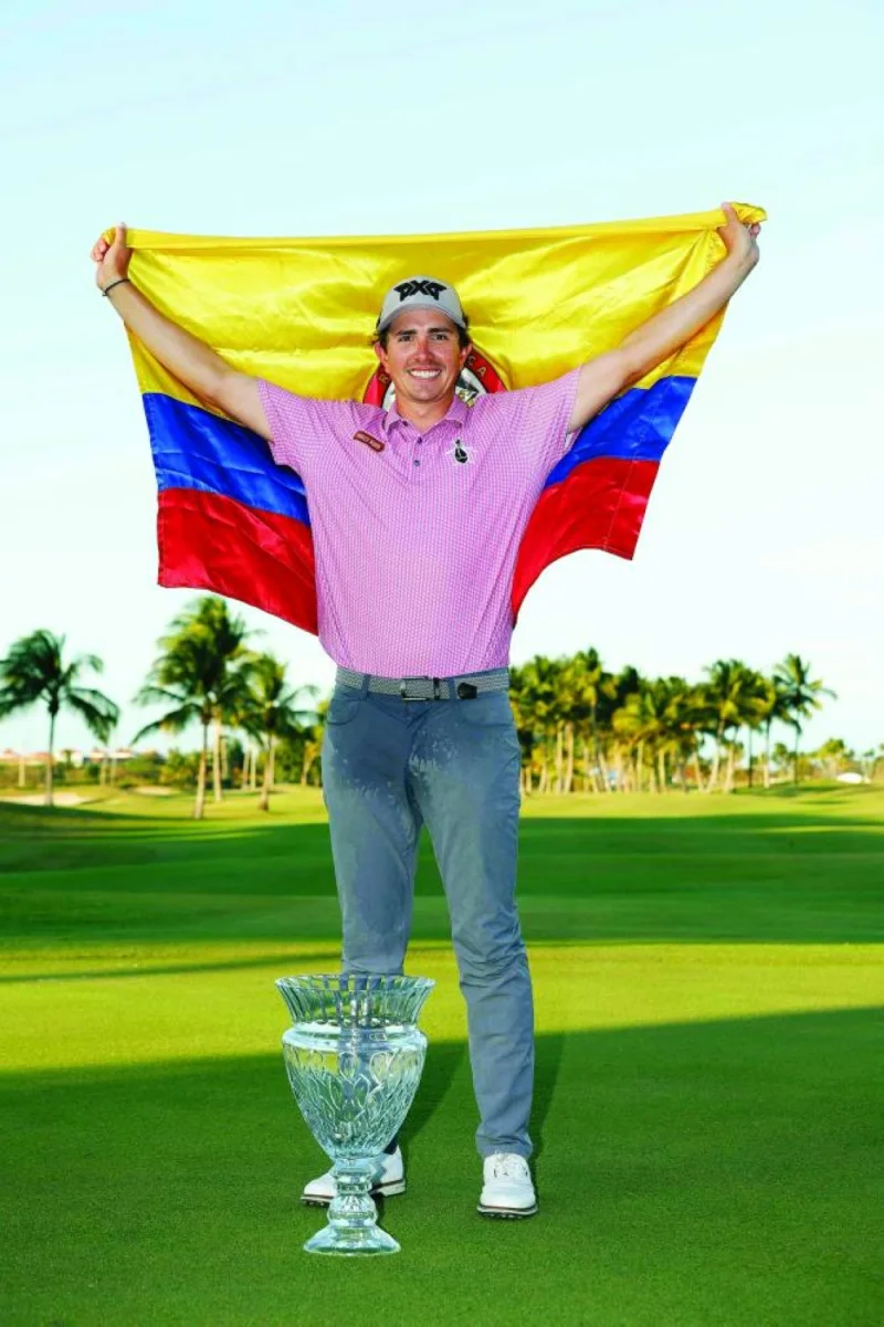 Nico Echavarria of Colombia poses with the trophy on the 18th green after winning the Puerto Rico Open at Grand Reserve Golf Club in Rio Grande, Puerto Rico. (AFP)