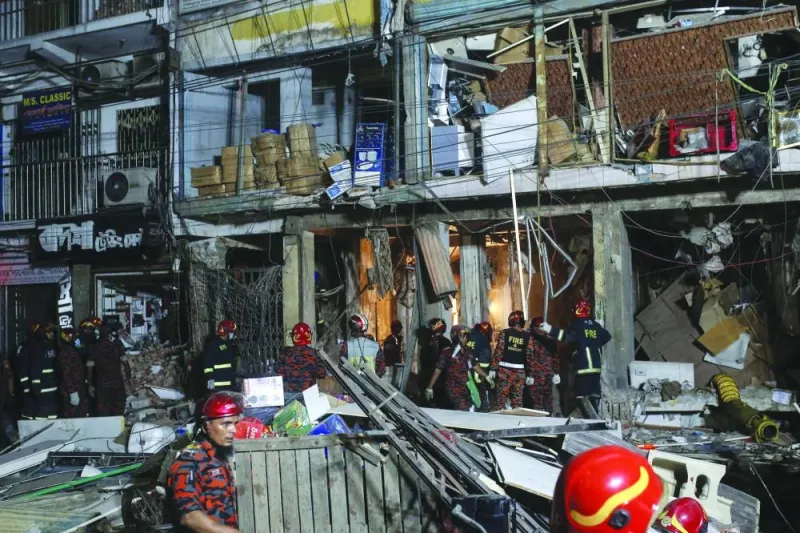Firefighters work amidst debris following an explosion inside a building in Dhaka yesterday. (AFP)