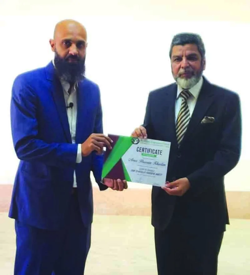 Riyaz Ahmed Bakali presenting a certificate to Amir Hussain Khadim.