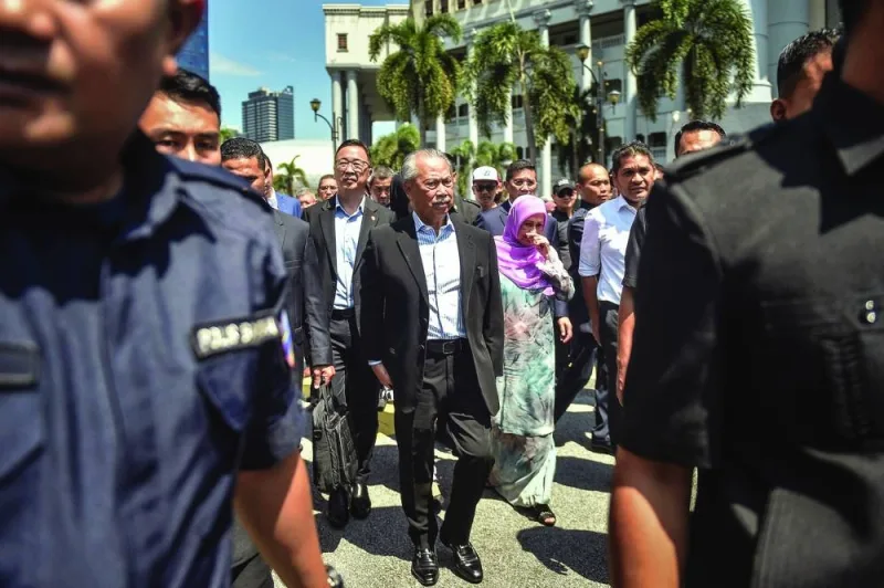 Former prime minister of Malaysia and Perikatan Nasional (PN) chairman Muhyiddin Yassin (centre) walks outside Kuala Lumpur High Court after being charged with corruption in Kuala Lumpur on Friday. 