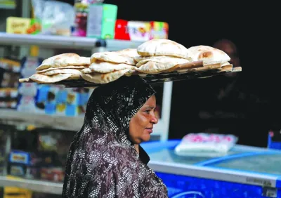 A woman carries bread as she leaves a bakery in Cairo. In February, consumer prices climbed an annual 31.9%, with food costs growing at a record pace. The pound has lost almost half of its value since last March as Egypt struggles with its worst foreign-exchange shortage in years.