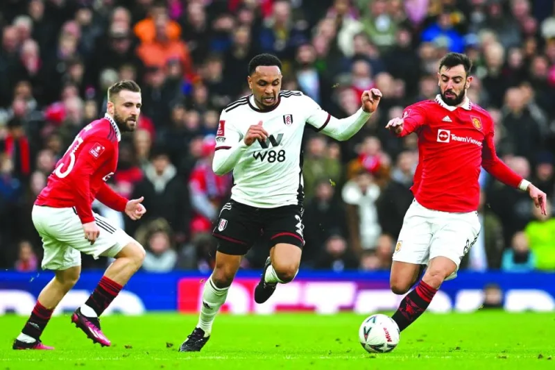 Fulham's Dutch defender Kenny Tete (centre) vies with Manchester United's Portuguese midfielder Bruno Fernandes (right) and Manchester United's English defender Luke Shaw (left) during the English FA Cup quarter-final at Old Trafford in Manchester, north-west England, yesterday. (AFP)