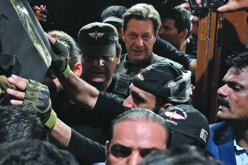 Pakistan’s former prime minister Imran Khan (centre) leaves after appearing before a court for a protective bail in relation to two cases in Lahore on Wednesday. (AFP)