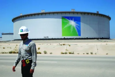 An Aramco employee walks near an oil tank at Saudi Aramco's Ras Tanura oil refinery and oil terminal in Saudi Arabia (file). Aramco agreed to the deal with North Huajin Chemical and Panjin Xincheng to start construction on the refinery and petrochemical complex in Liaoning Province, Amin Nasser, the Saudi company’s president and chief executive officer, said at the China Development Forum in Beijing on Sunday.