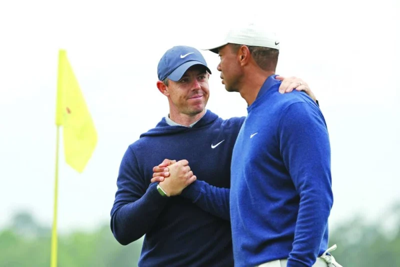 Rory McIlroy (right) of Northern Ireland and Tiger Woods of the United States shake hands on the 18th green during a practice round prior to the 2023 Masters Tournament at Augusta National Golf Club in Augusta, Georgia, yesterday. (AFP)