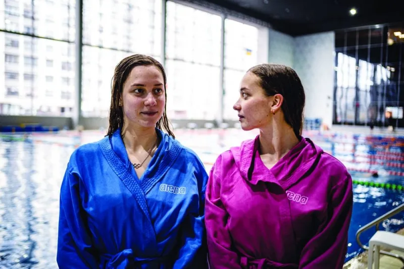 Ukrainian Olympic artistic swimmers Maryna (left) and Vladyslava Aleksiiva from Kharkiv, pose during an interview after their training session in Kyiv, amid the Russian invasion of Ukraine. (AFP)