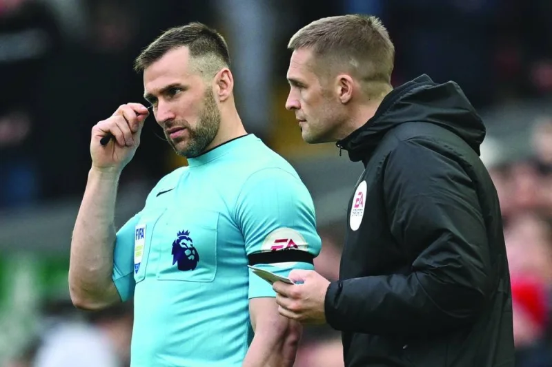 Fourth official Craig Pawson talks to assistant referee and linesman Assistant Referee Constantine Hatzidakis during the English Premier League match between Liverpool and Arsenal at Anfield in Liverpool on Sunday. (AFP)