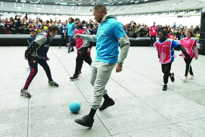 Paris Saint-Germain’s French forward Kylian Mbappe takes part in a football match with children from the “Premiers de Cordee” association at the Stade de France in Saint-Denis, north of Paris, on Wednesday. (AFP)