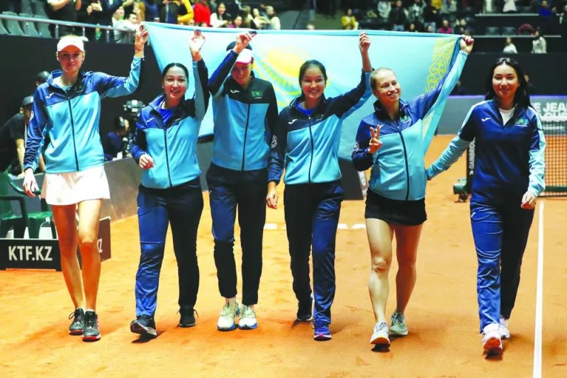 Kazakhstan’s Elena Rybakina (left) celebrates with teammates after winning her singles match against Poland’s Magda Linette in Billie Jean King Cup Qualifiers in Astana, Kazakhstan, on Saturday. (Reuters)