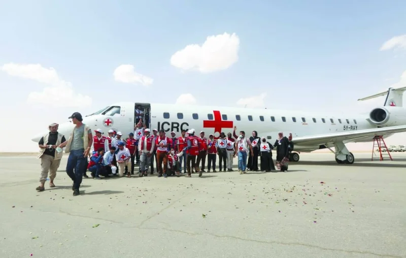 People stand next to an International Committee of the Red Cross-chartered plane to carry freed prisoners, at Marib Airport, amid a prisoner swap between the two sides in the Yemen conflict, yesterday.