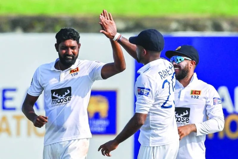 Sri Lanka’s Prabath Jayasuriya left) celebrates with teammates after taking the wicket of Ireland’s Harry Tector (not pictured) during the second day of the first Test at the Galle International Cricket Stadium in Galle on Monday. (AFP)