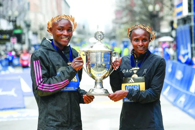 Evans Chebet of Kenya (left) and Hellen Obiri of Kenya (right) pose with the winner's trophy after winning their respective divisions in the 2023 Boston Marathon. (USA TODAY Sports)