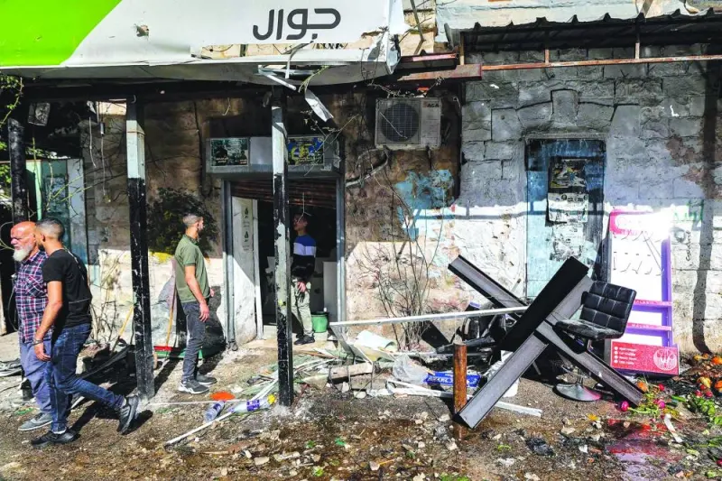 People gather outside a ransacked building following an Israeli military operation at the Jenin camp for Palestinian refugees in the occupied West Bank, yesterday.