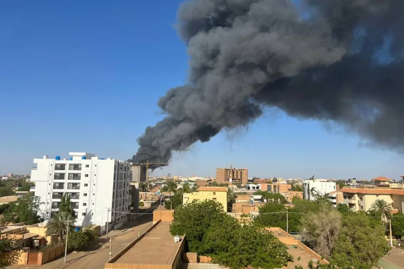 A column of smoke rises behind buildings near the airport area in Khartoum, amid fighting between the army and paramilitaries following the collapse of a 24-hour truce. AFP